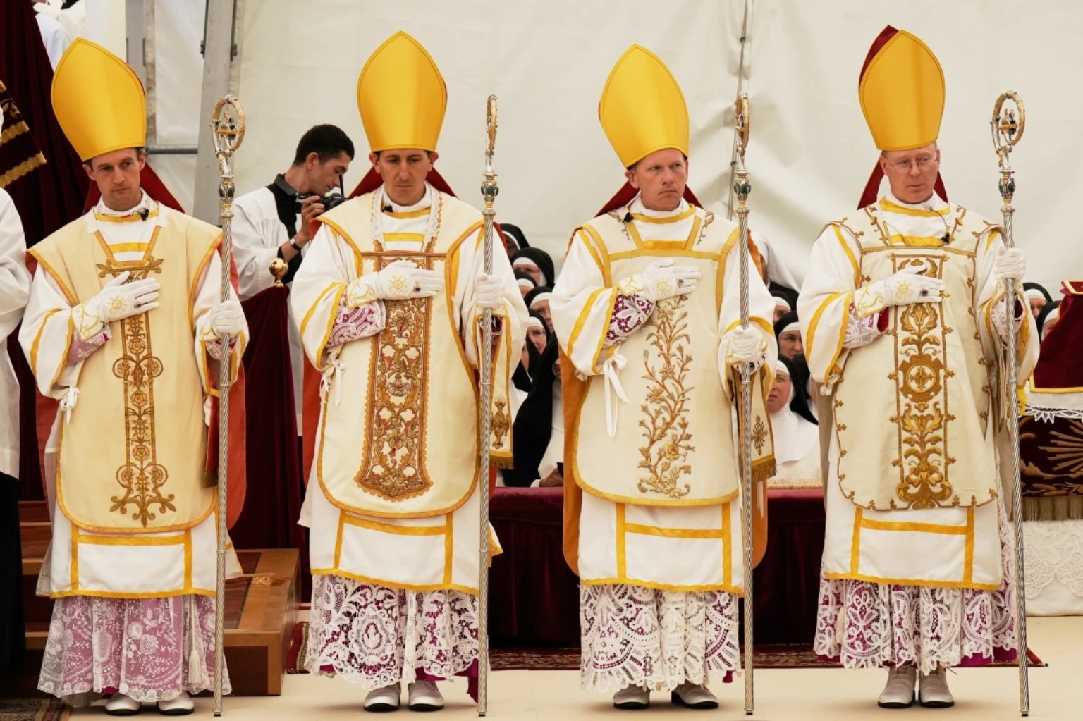 Les quatre nouveaux évêques d’Écône avec mitres, crosses, gants et ornements liturgiques.